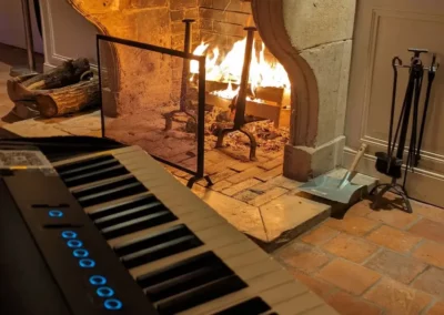 Piano numérique installé près d’une cheminée allumée