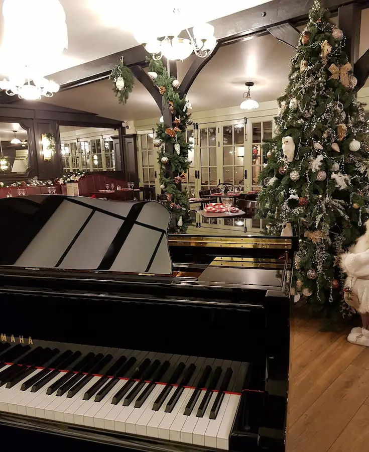 Piano à queue installé dans un restaurant décoré pour Noël