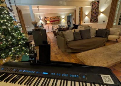Piano numérique installé devant un sapin dans un salon décoré pour Noël