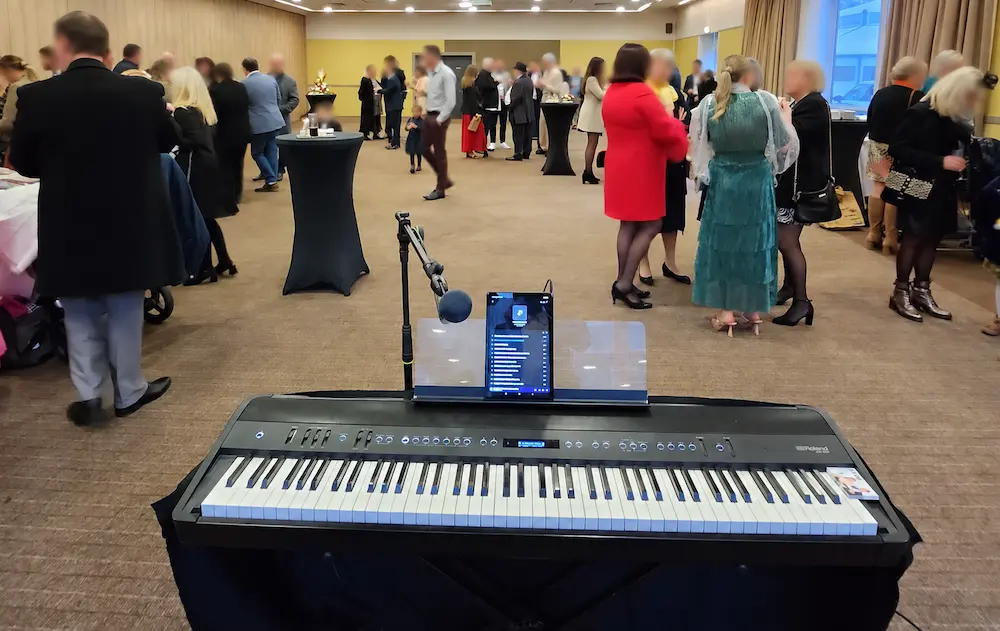 Piano numérique et micro installés devant les invités d’un cocktail d’entreprise