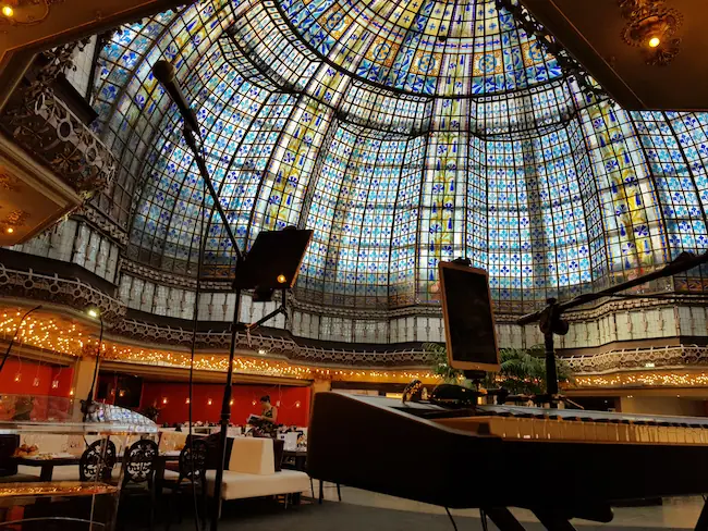 Piano et micros installés dans une salle de réception décorée de vitraux