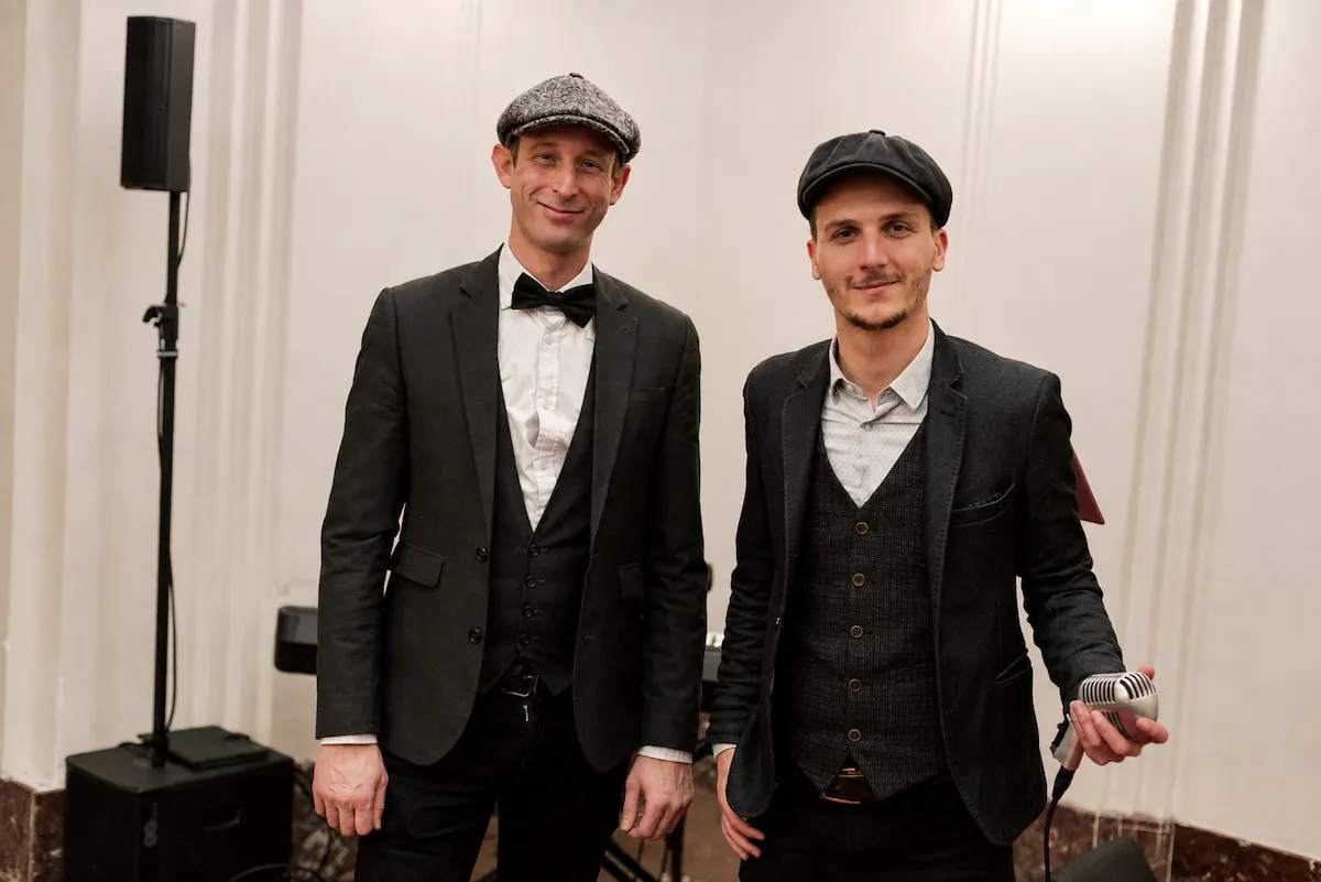 Wary et Charlie en costumes et casquettes vintage lors d’une prestation du duo Swing Caps